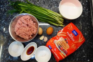 Prepare all ingredients for chinese dumpling, plain flour, cold water, chive, eggs, garlic, minced pork and seasonings