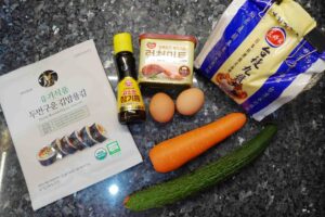 Korean rice roll (kim bap) ingredients are prepared - seaweed, korean sesame oil, eggs. luncheon meat, carrot and rice