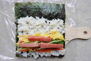 Korean rice roll kim bap recipe - wrap all ingredients using a piece of seaweed.