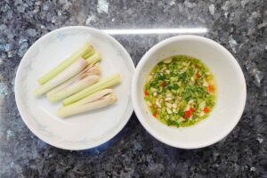 Thai-style steam fish recipe - lemongrasses are laying on the left and the mixed sauce at the right