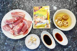 malaysian-bak-kut-teh-pork-ribs-soup- pork ribs at the left, soup pack at the middle, mushroom at right hand side with garlic and all seasoning.