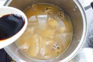 Adding black soy sauce into the brown bak kut teh